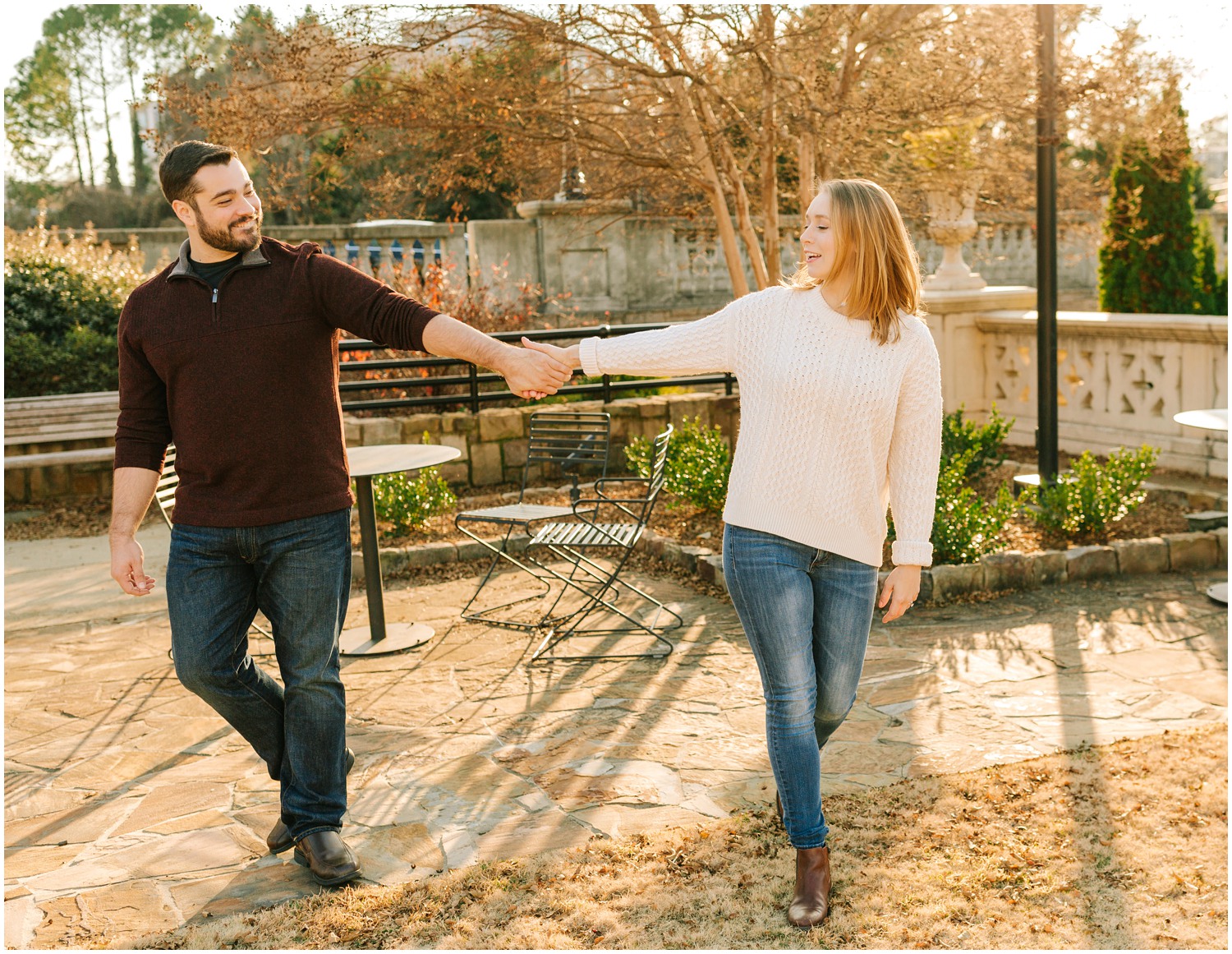 couple walks through patio at Midtown Park during engagement photos 