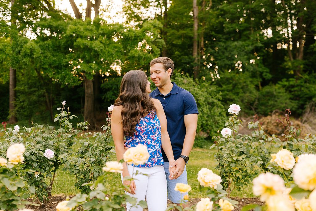 Chelsea Renay captures engaged couple smiling at each other near yellow roses 
