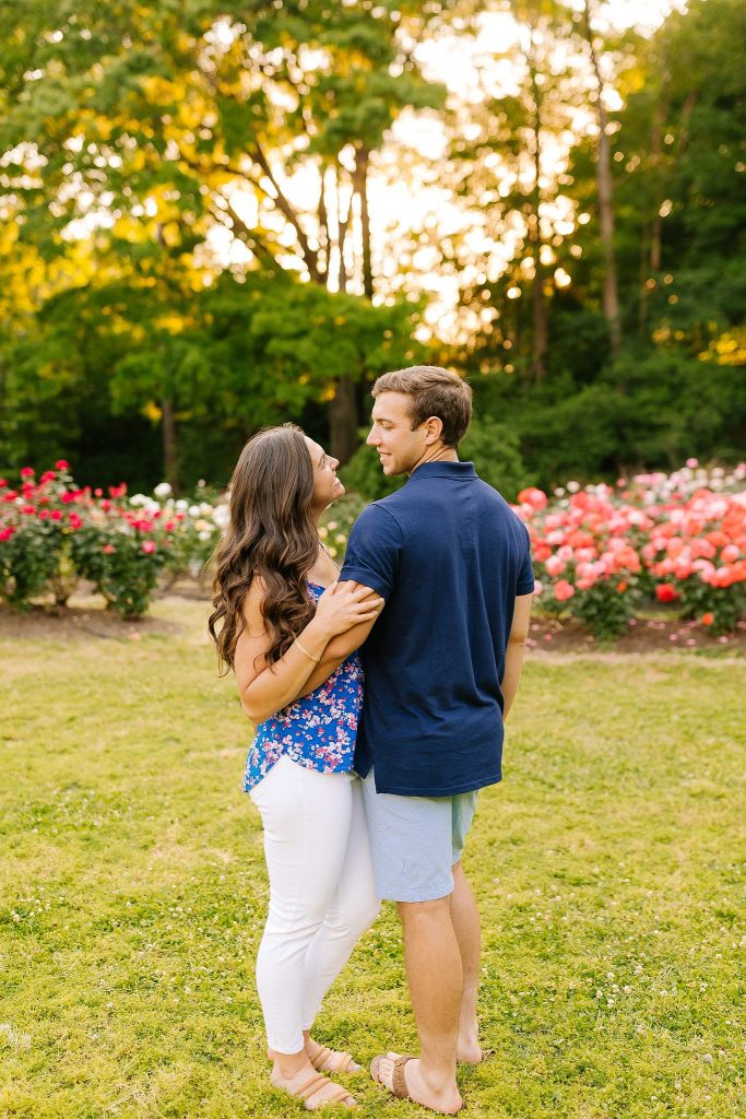 engaged couple hugs during spring engagement portraits in Raleigh Rose Garden