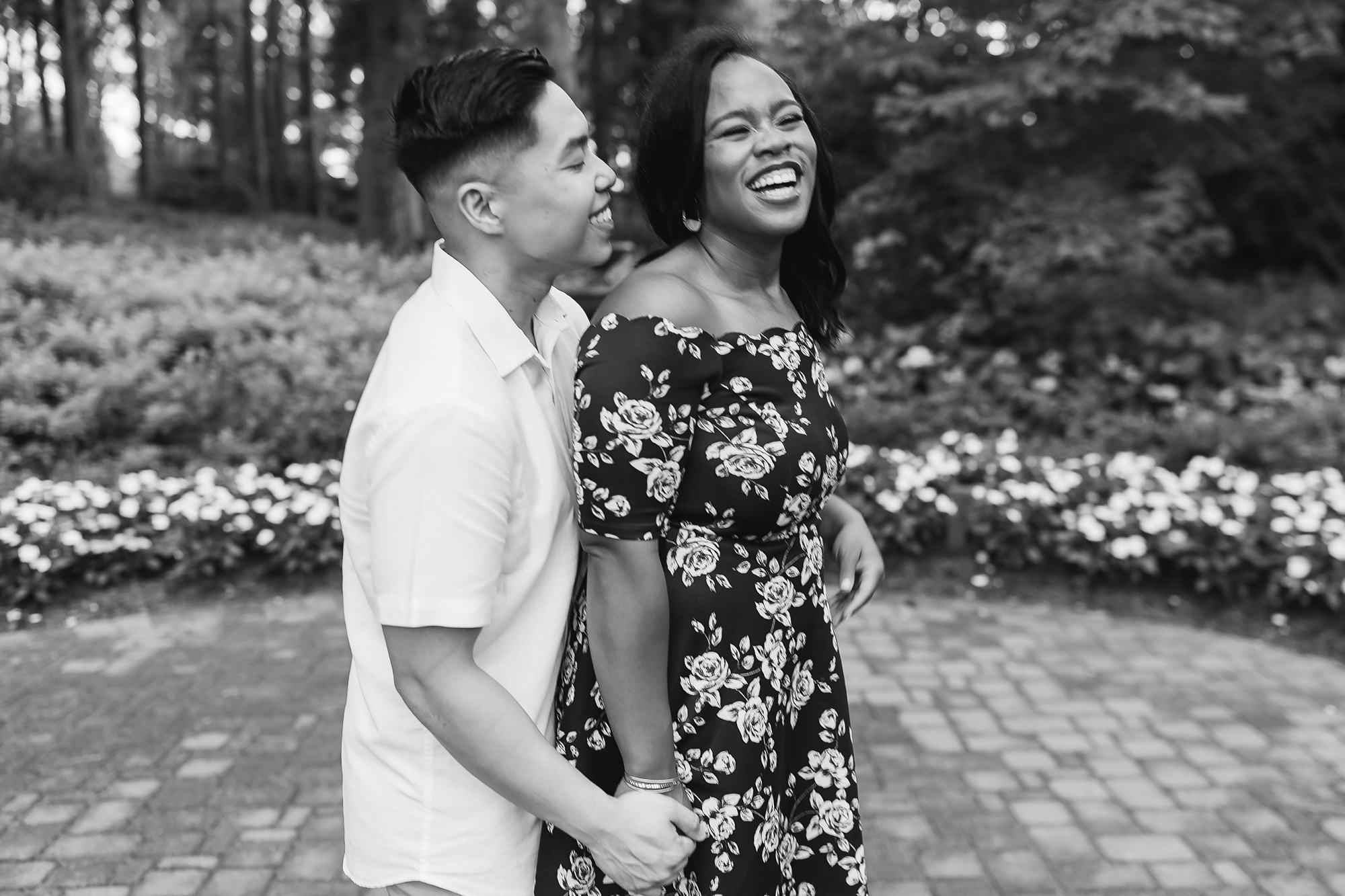 couple laughs during Raleigh NC engagement session in gardens