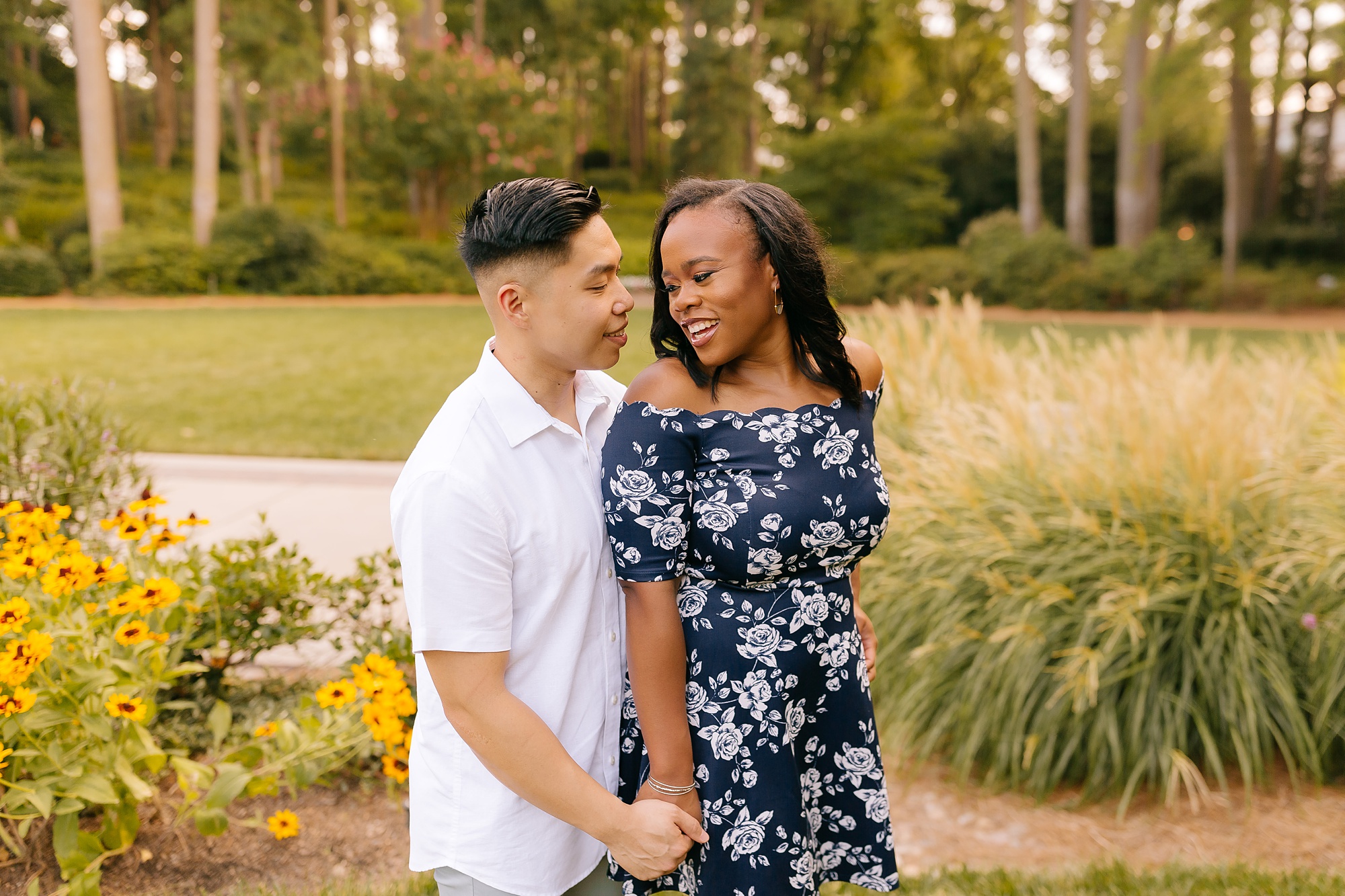 groom and bride hold hands whispering in WRAL Gardens