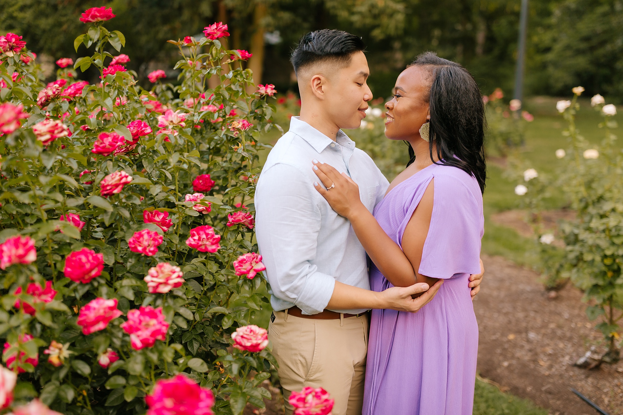 couple kisses by rose bush in WRAL Gardens