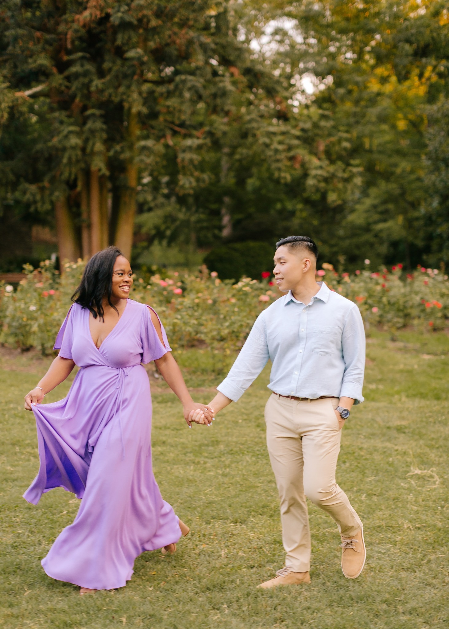 couple walks during engagement phots in WRAL Gardens