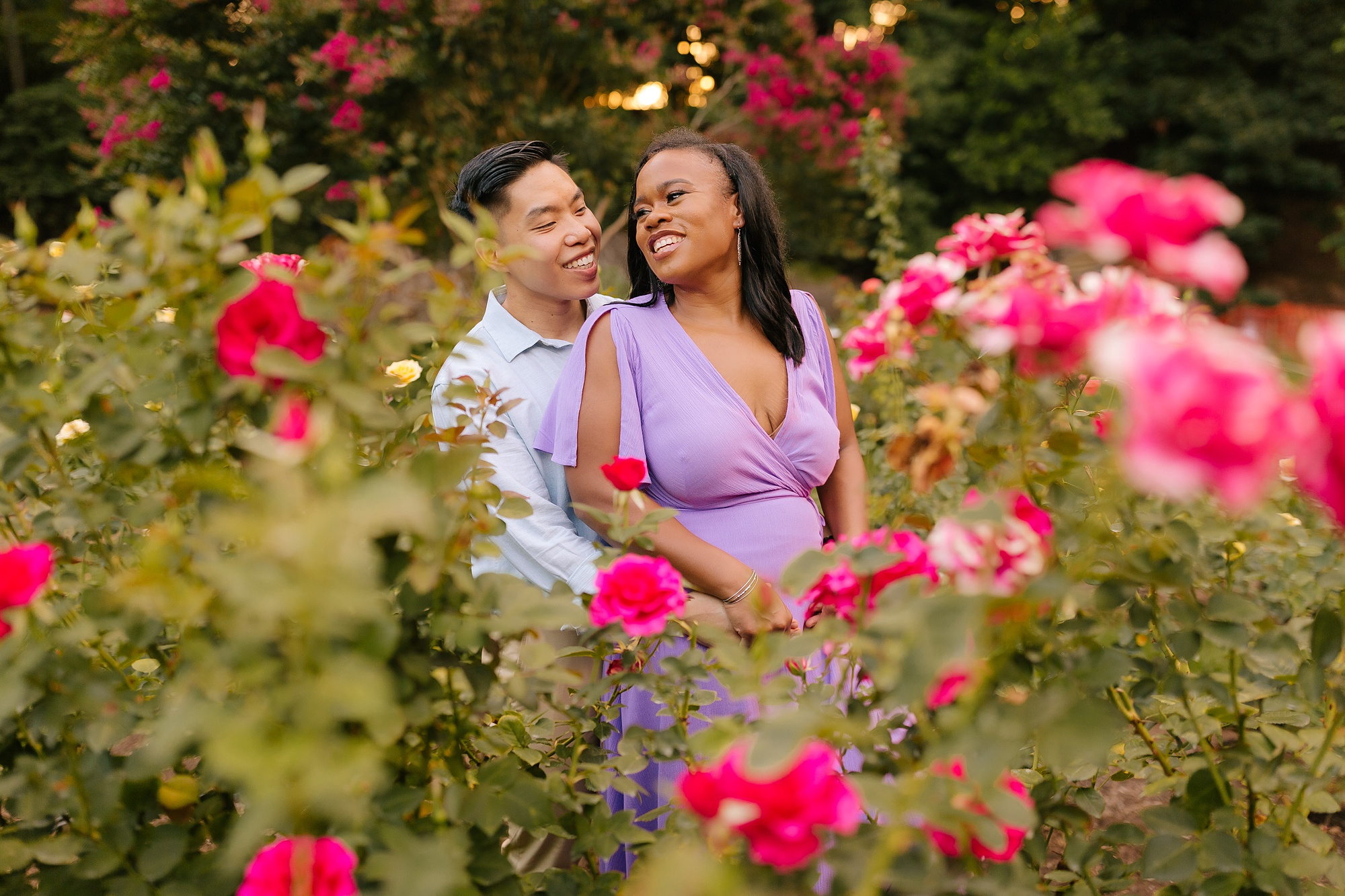 couple poses in WRAL Gardens laughing during engagement session