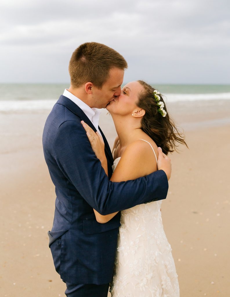 bride kisses groom during beach wedding photos