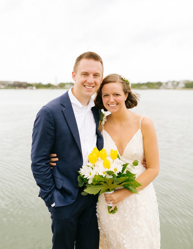 bride and groom pose in front of sound on Ocracoke Island