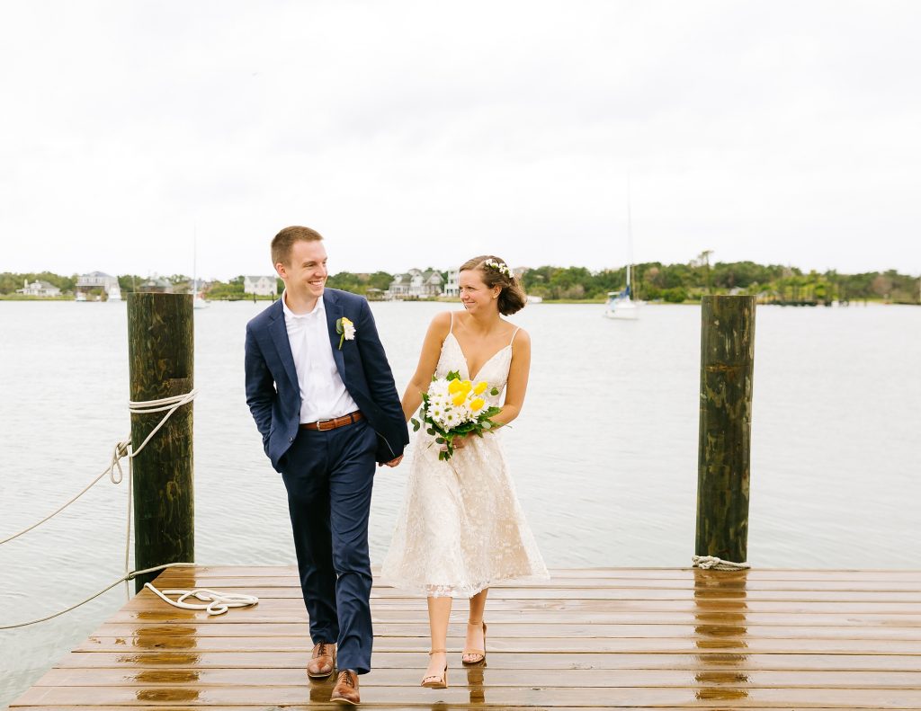 bride and groom walk on dock in Ocracoke Island
