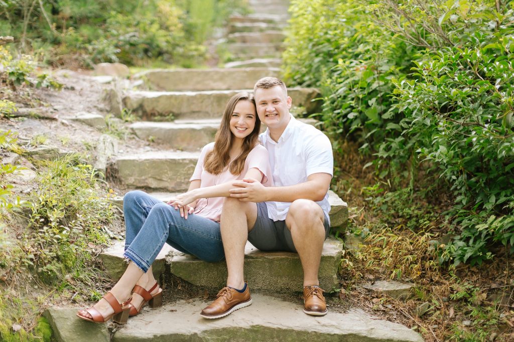 engaged couple sits on stone staircase