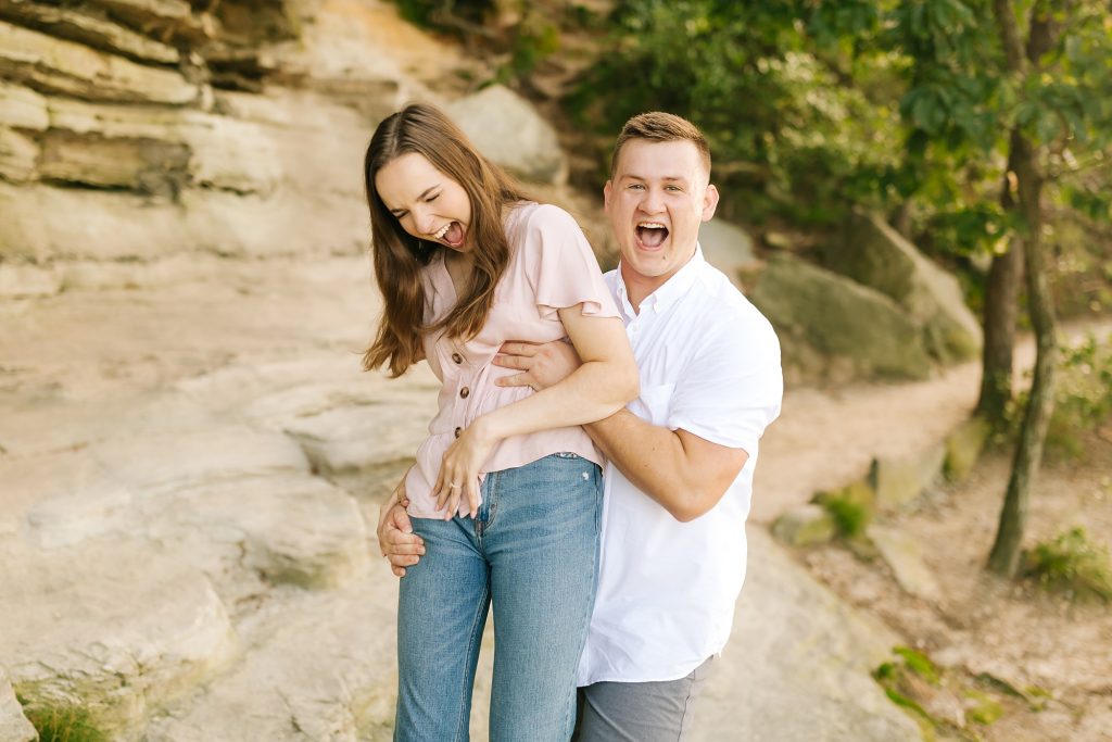 groom lifts bride playfully during engagement photos
