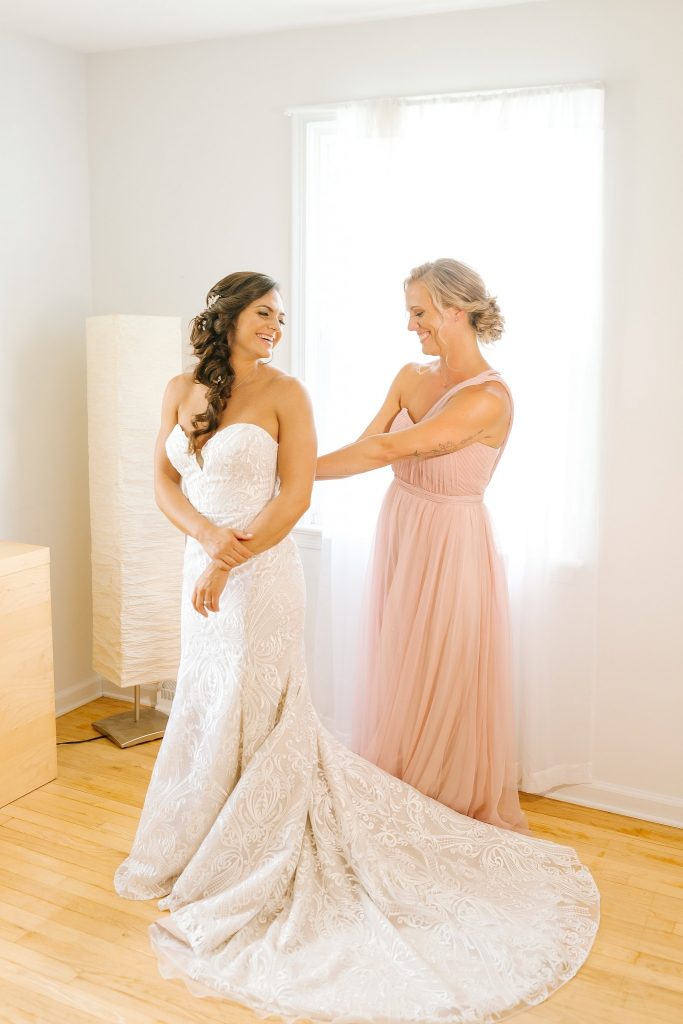 bride puts on wedding dress at childhood home