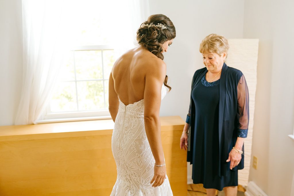 bride shows of wedding gown to mom