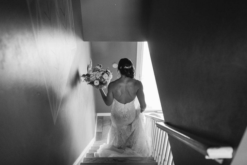 bride walks down steps in childhood home