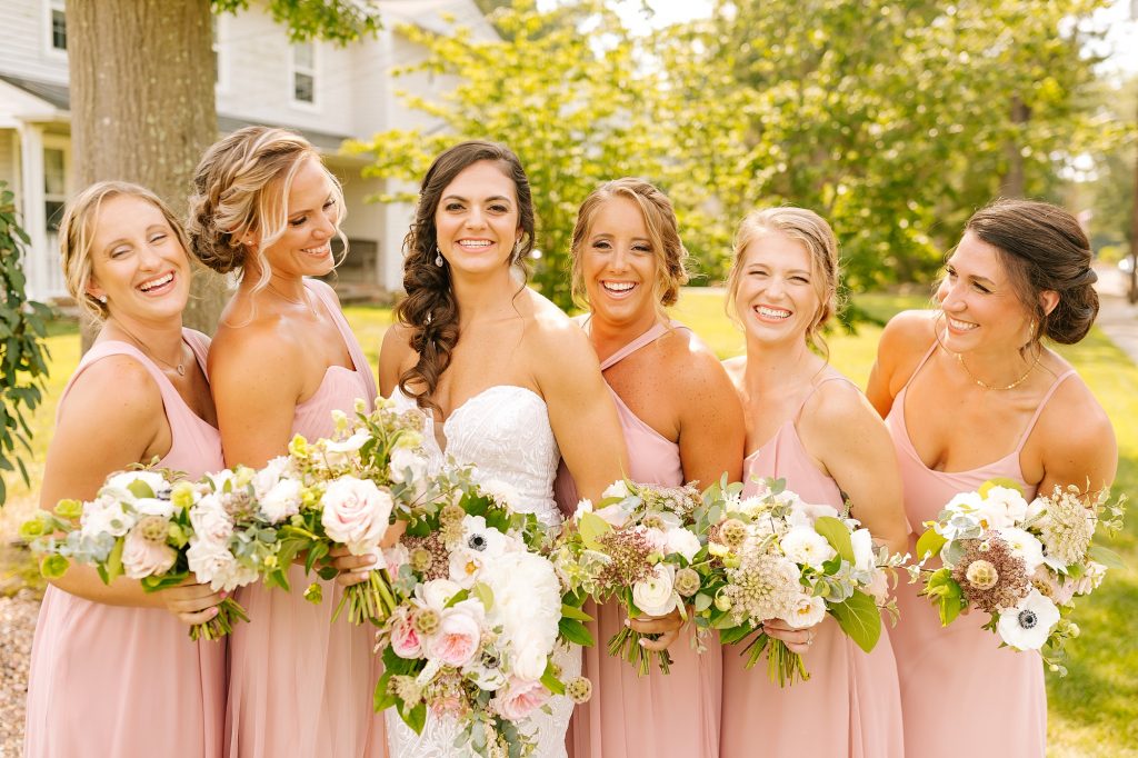 Vineland NJ bridesmaids smile wearing pink dresses with white bouquets