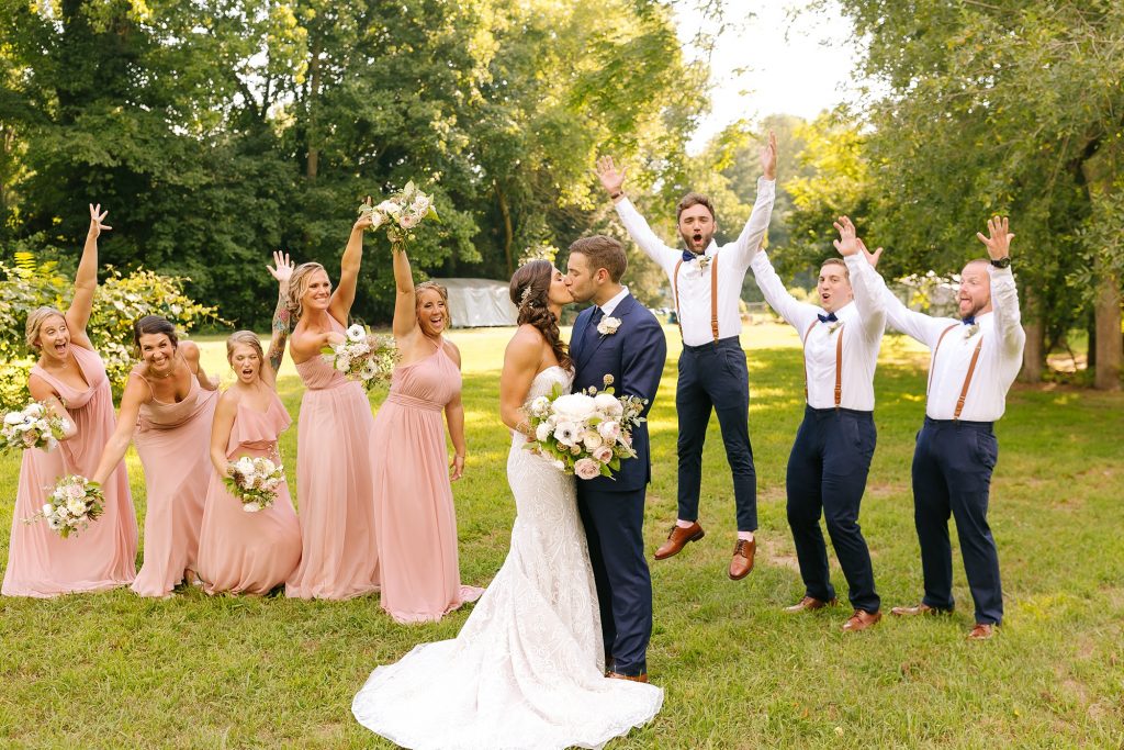 groomsmen jump during portraits with bridal party