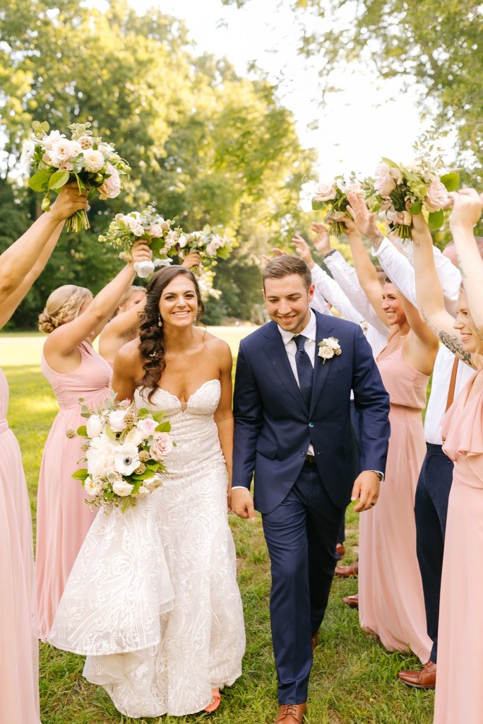 wedding party creates tunnel for bride and groom to walk through