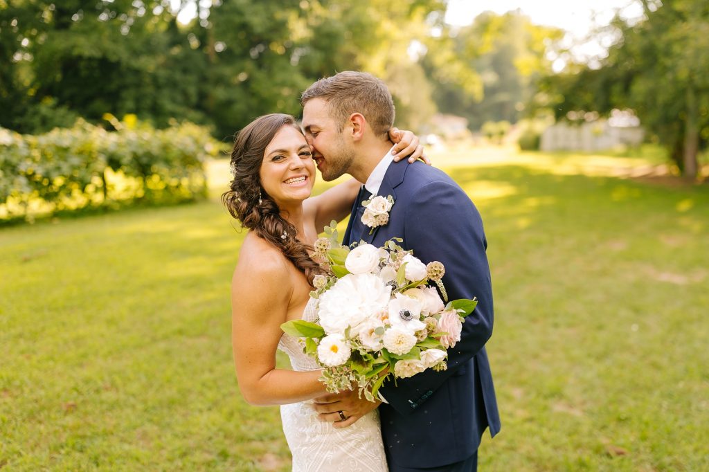 groom nuzzles bride's forehead during portraits