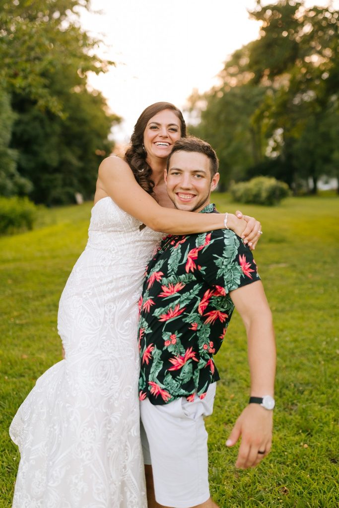 groom in Hawaiian shirt lifts bride with one arm