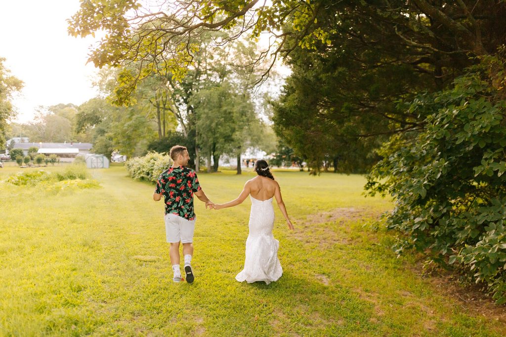 bride in wedding dress walks with groom in Hawaiian shirt