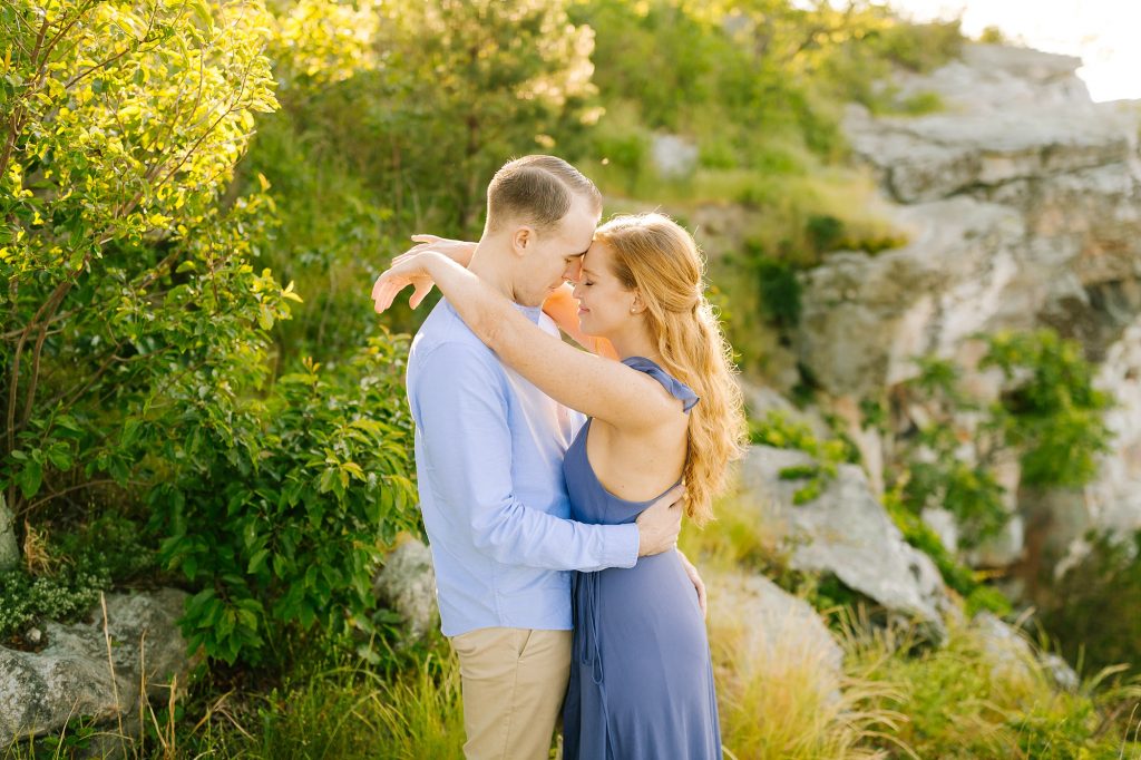 bride and groom pose by rocks on Pilot Mountain with Chelsea Renay