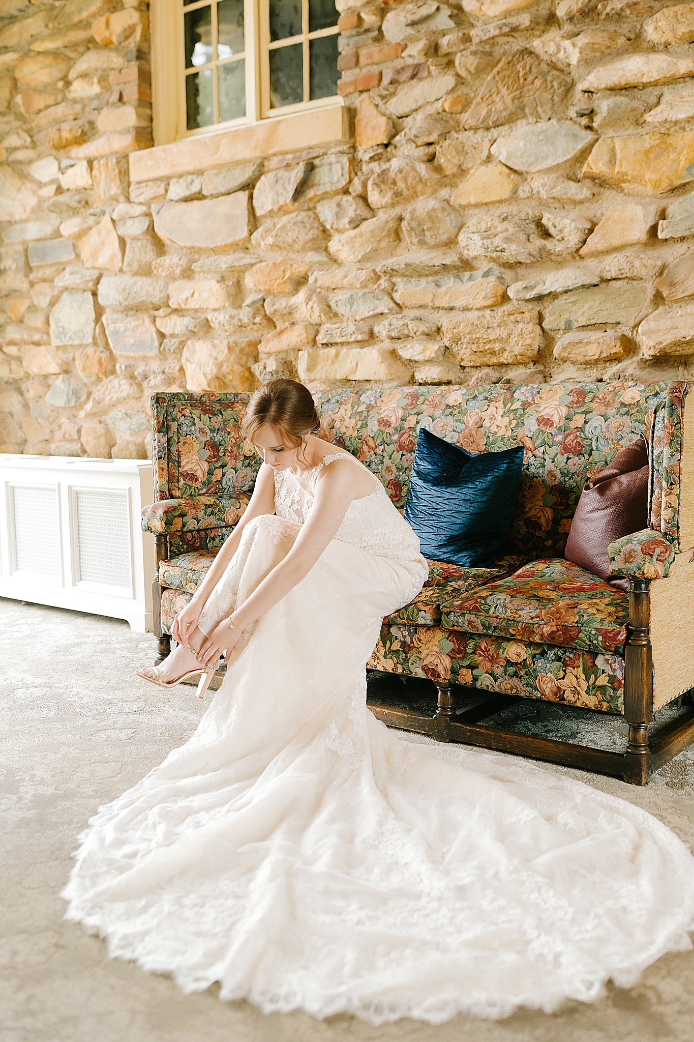 bride puts on shoes for wedding day in NC