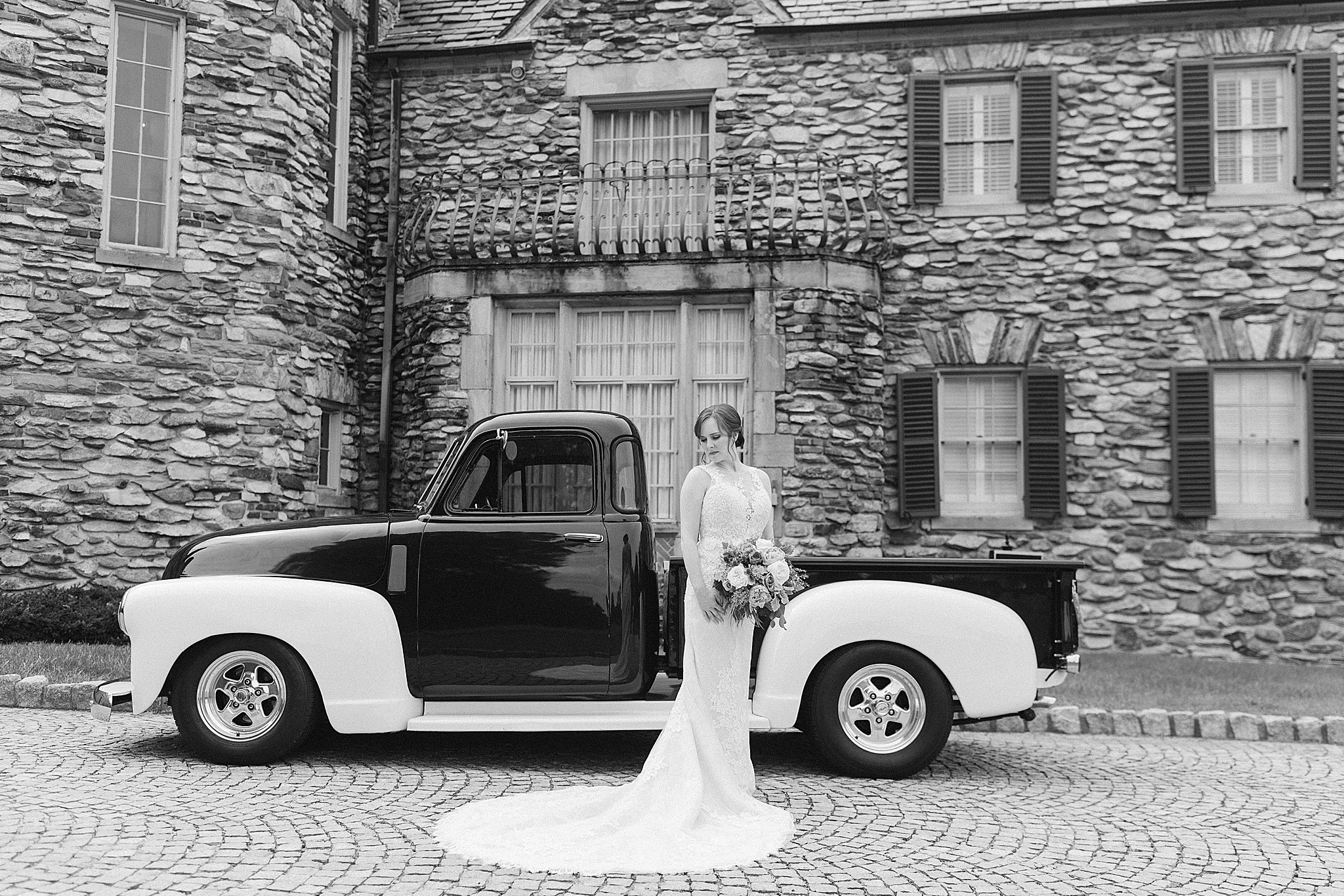 bride poses with vintage truck outside the Graylyn Estate