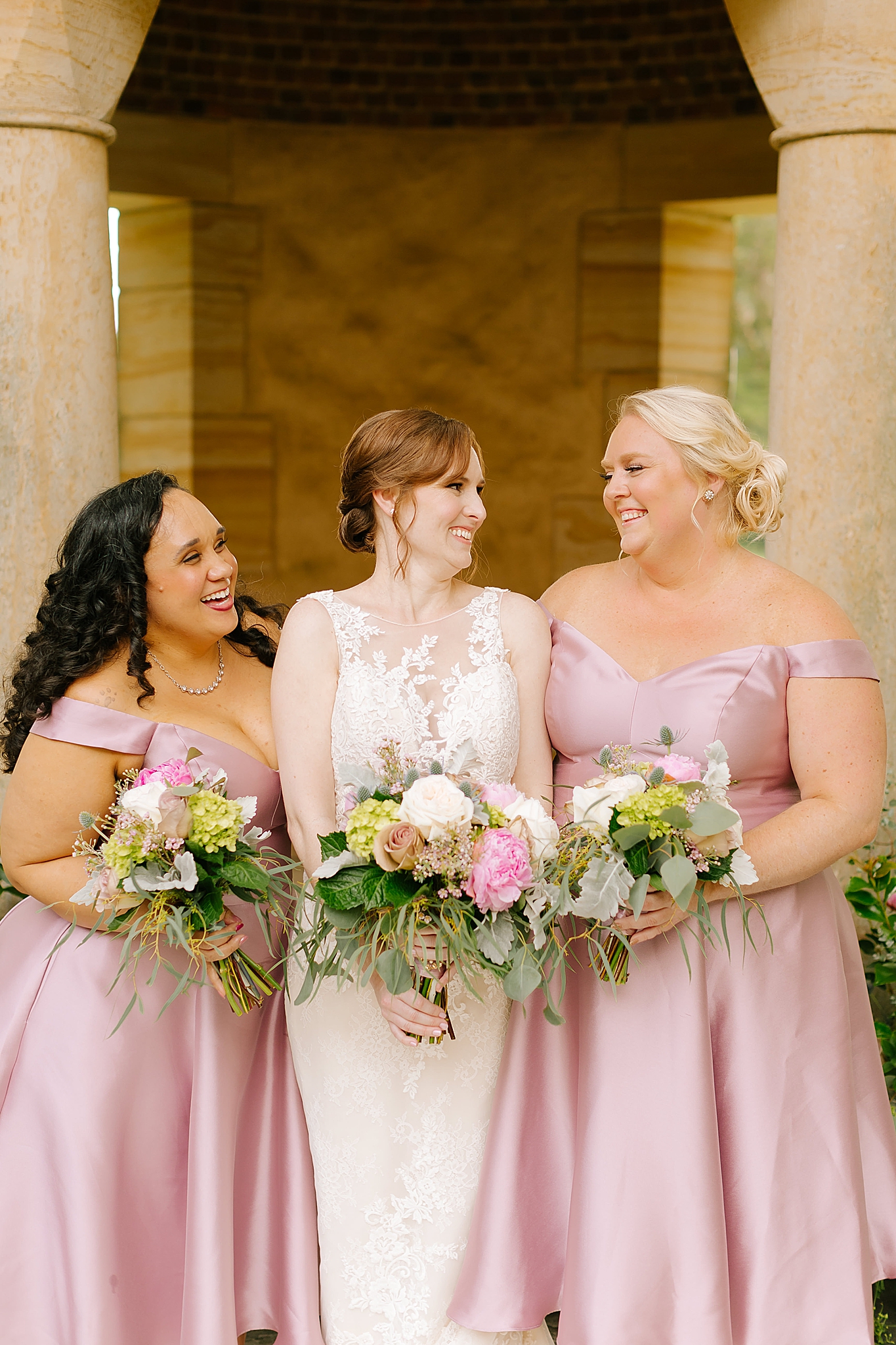 bridesmaids hold bouquets with bride at Graylyn Estate