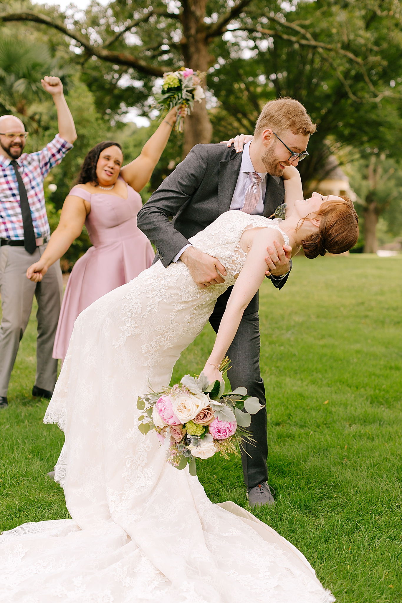 groom dips bride during wedding party portraits