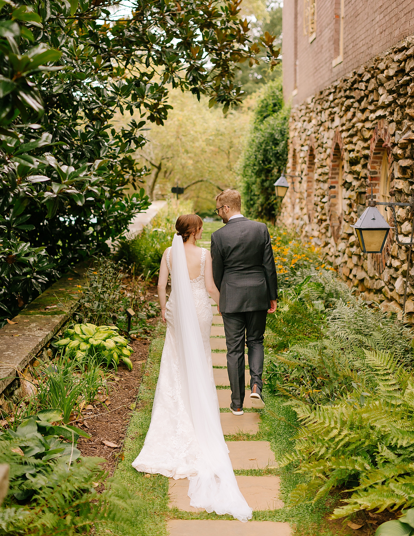 bride and groom walk through gardens at Graylyn Estate