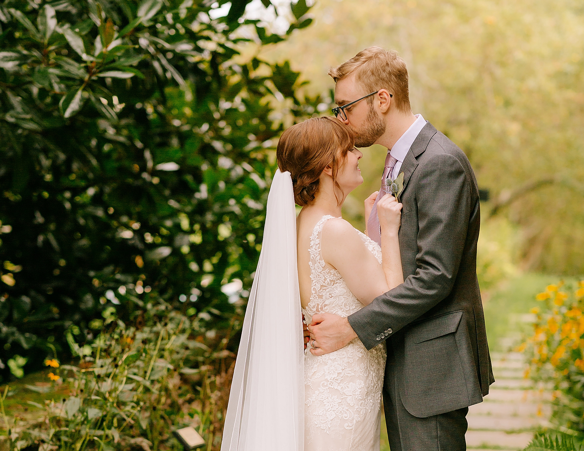 groom kisses bride's forehead