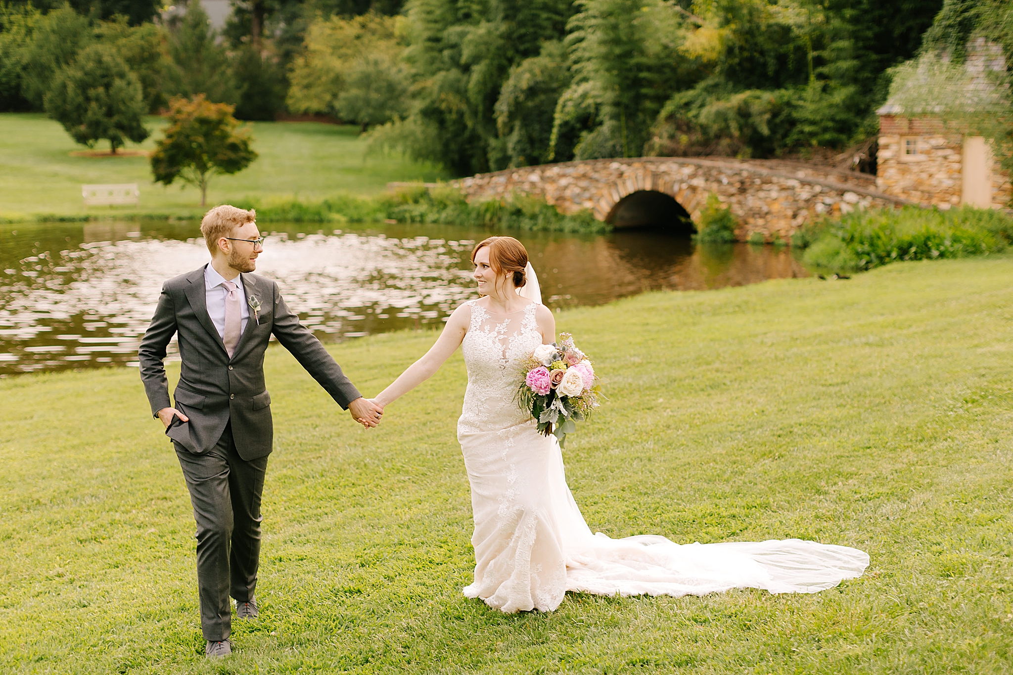 bride and groom walk through lawn at Graylyn Estate