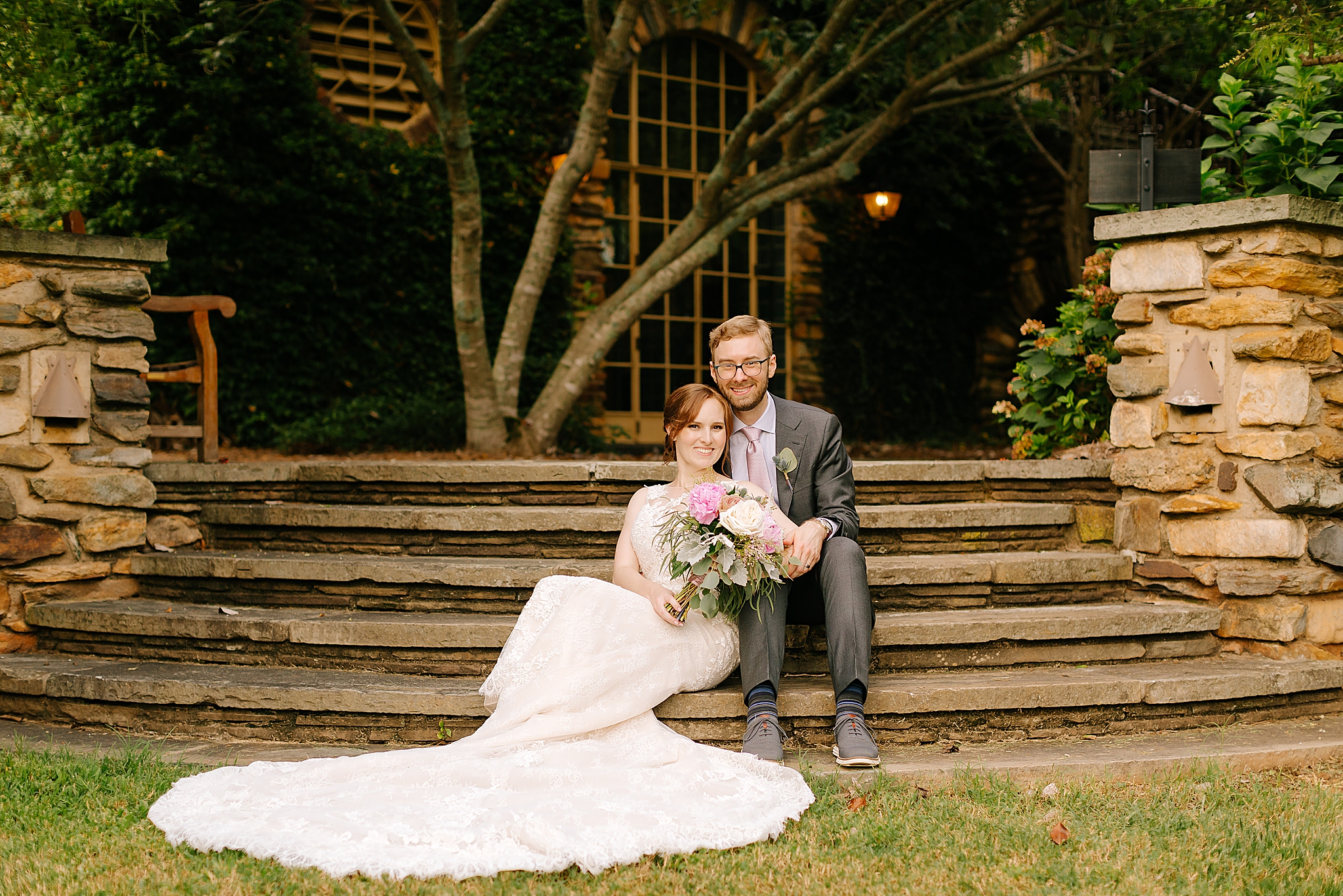 newlyweds sit on steps at Graylyn Estate