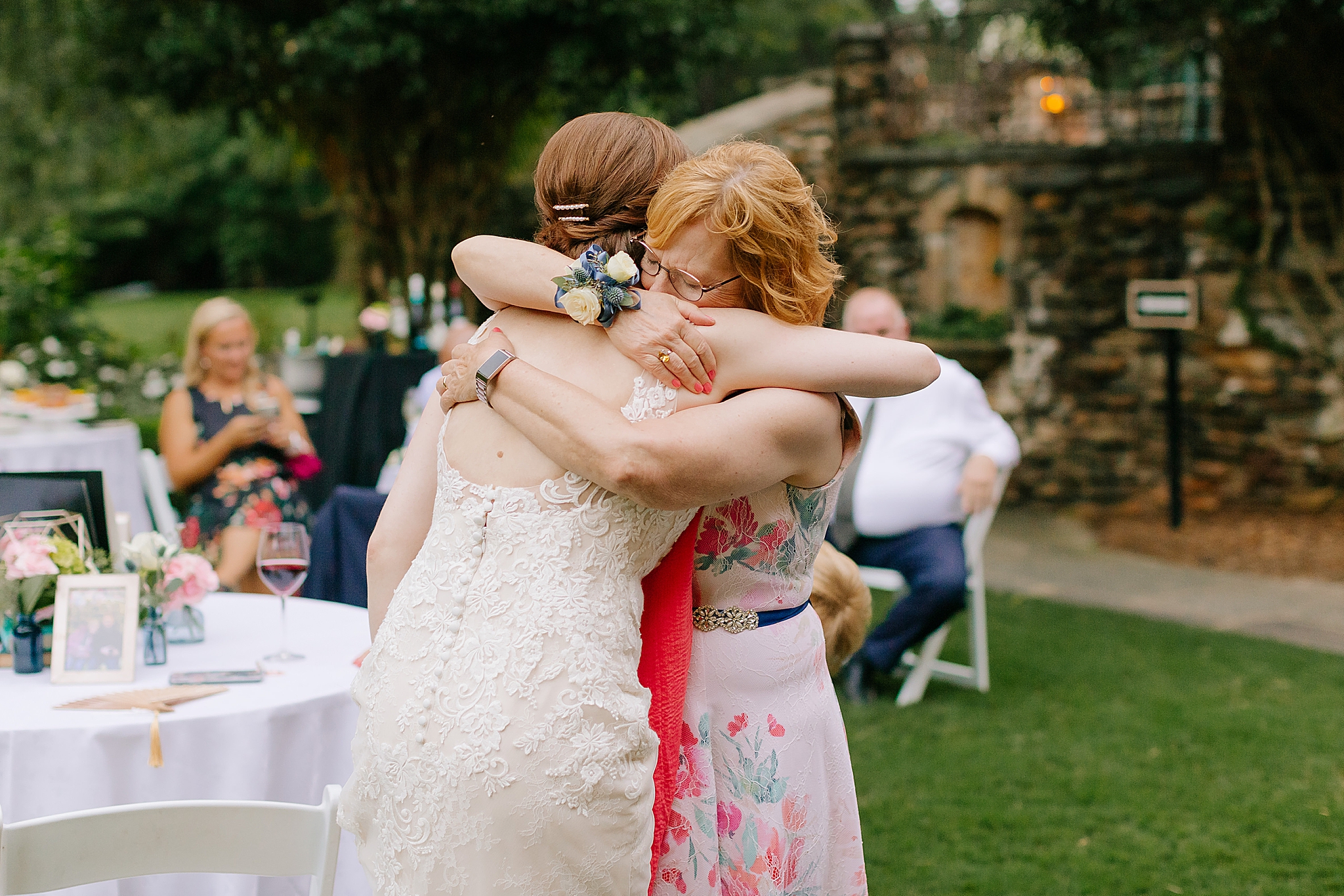 bride hugs mom during wedding reception