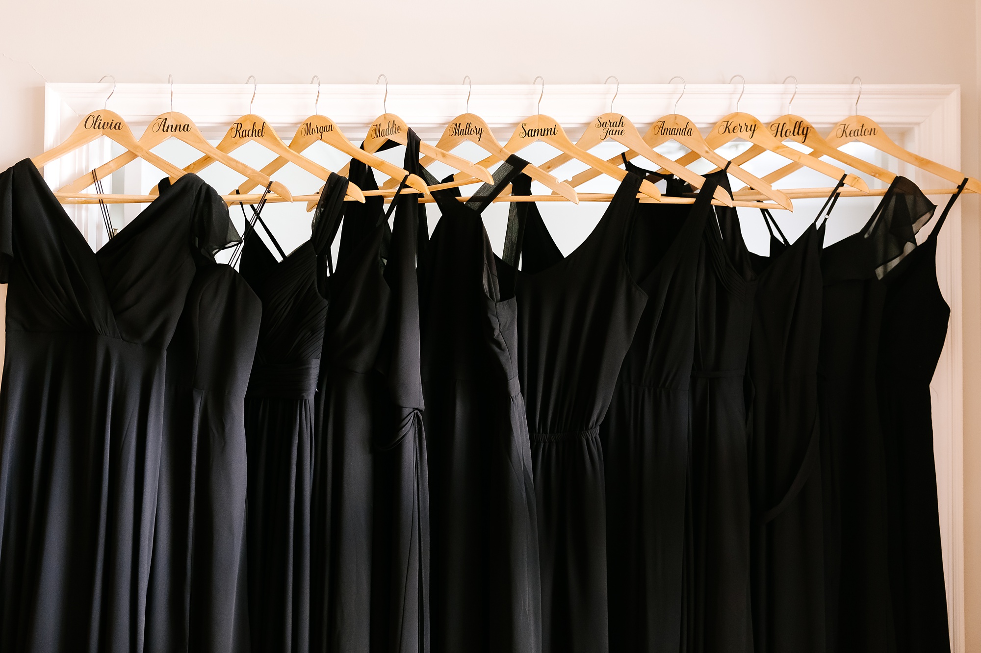 black bridesmaids gowns hang in bedroom