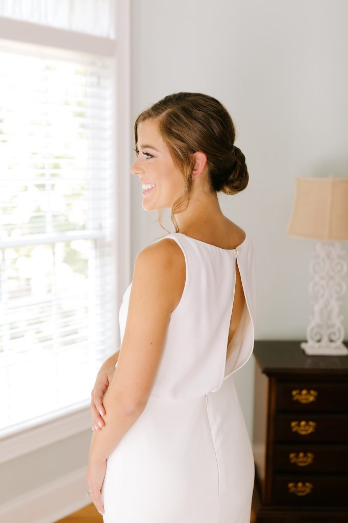 bride looks out window before CLT wedding