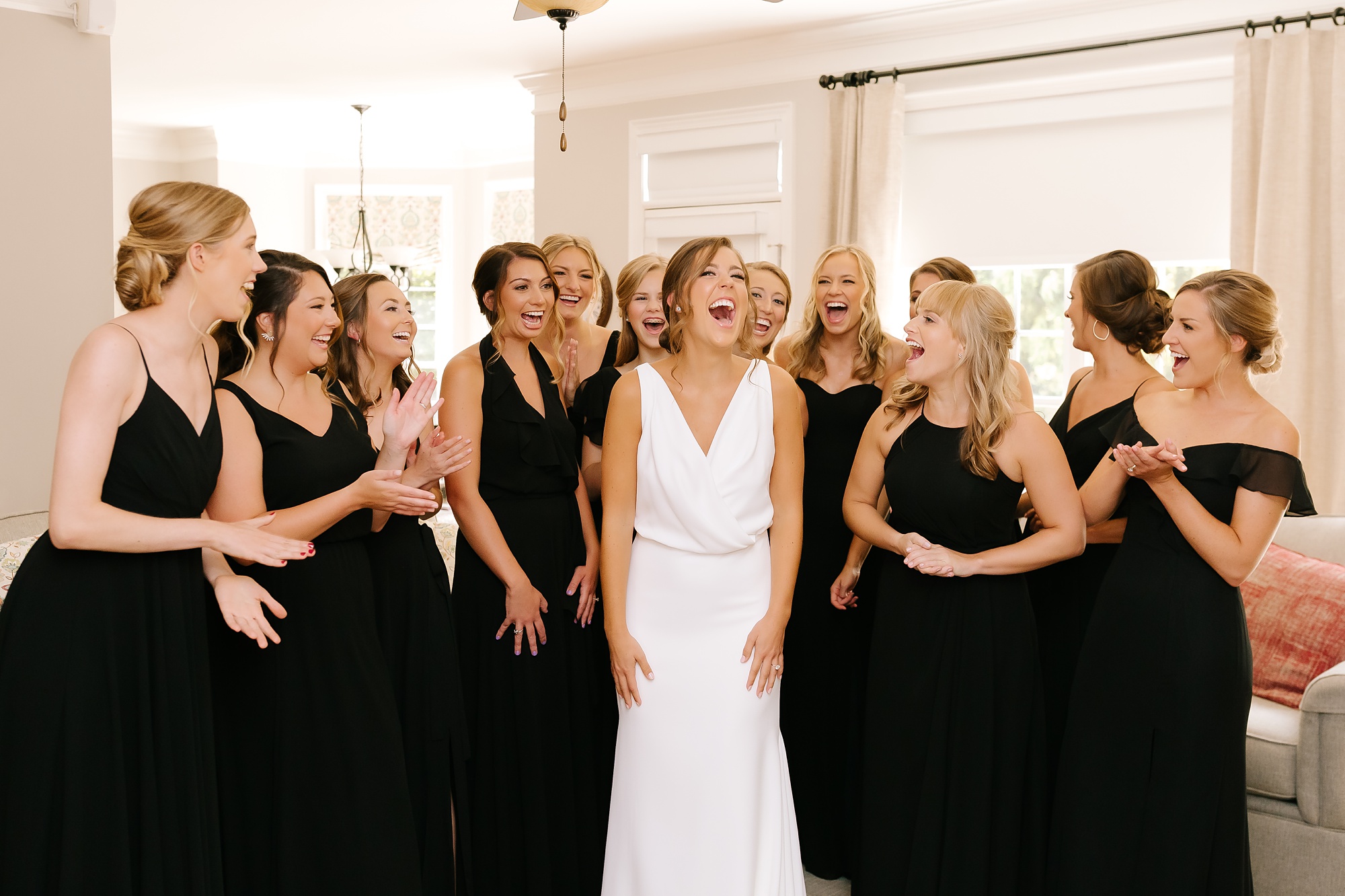 bride laughs after first look with bridesmaids