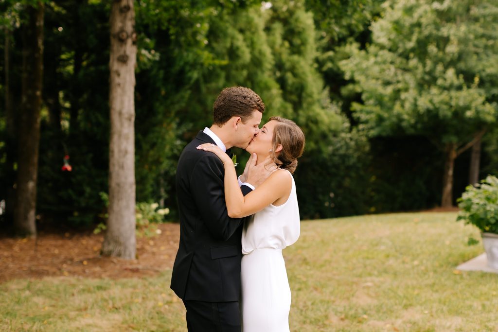 bride and groom kiss during first look before microwedding 