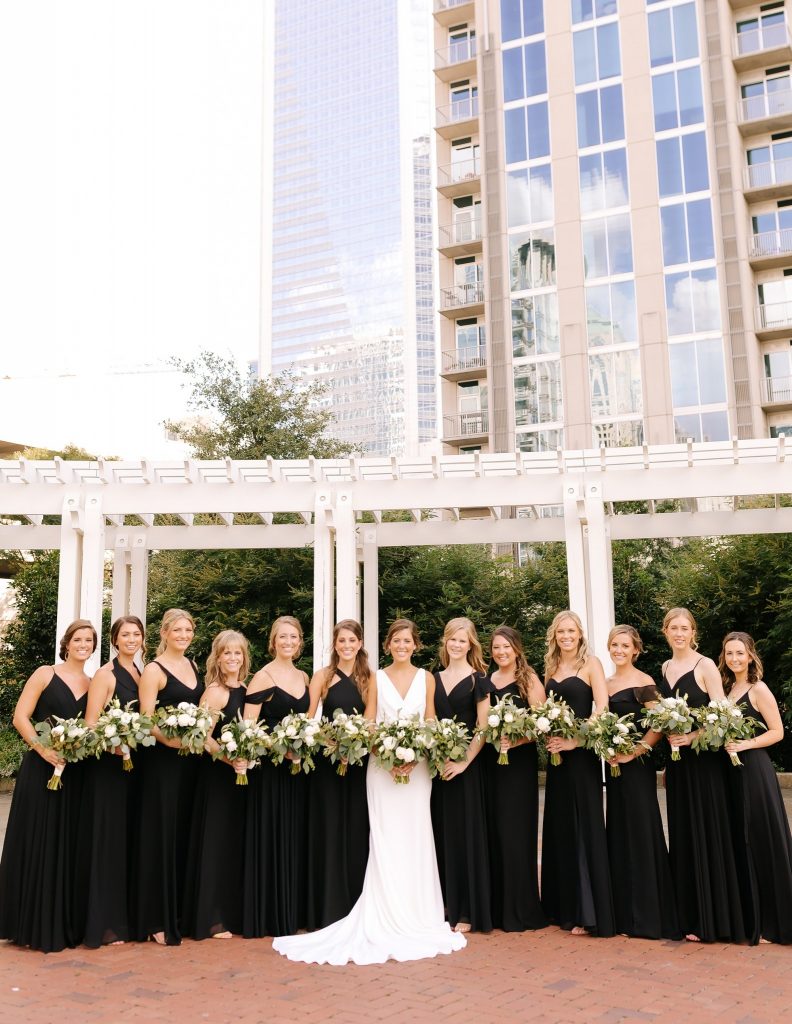bridesmaids pose with bride in uptown Charlotte park
