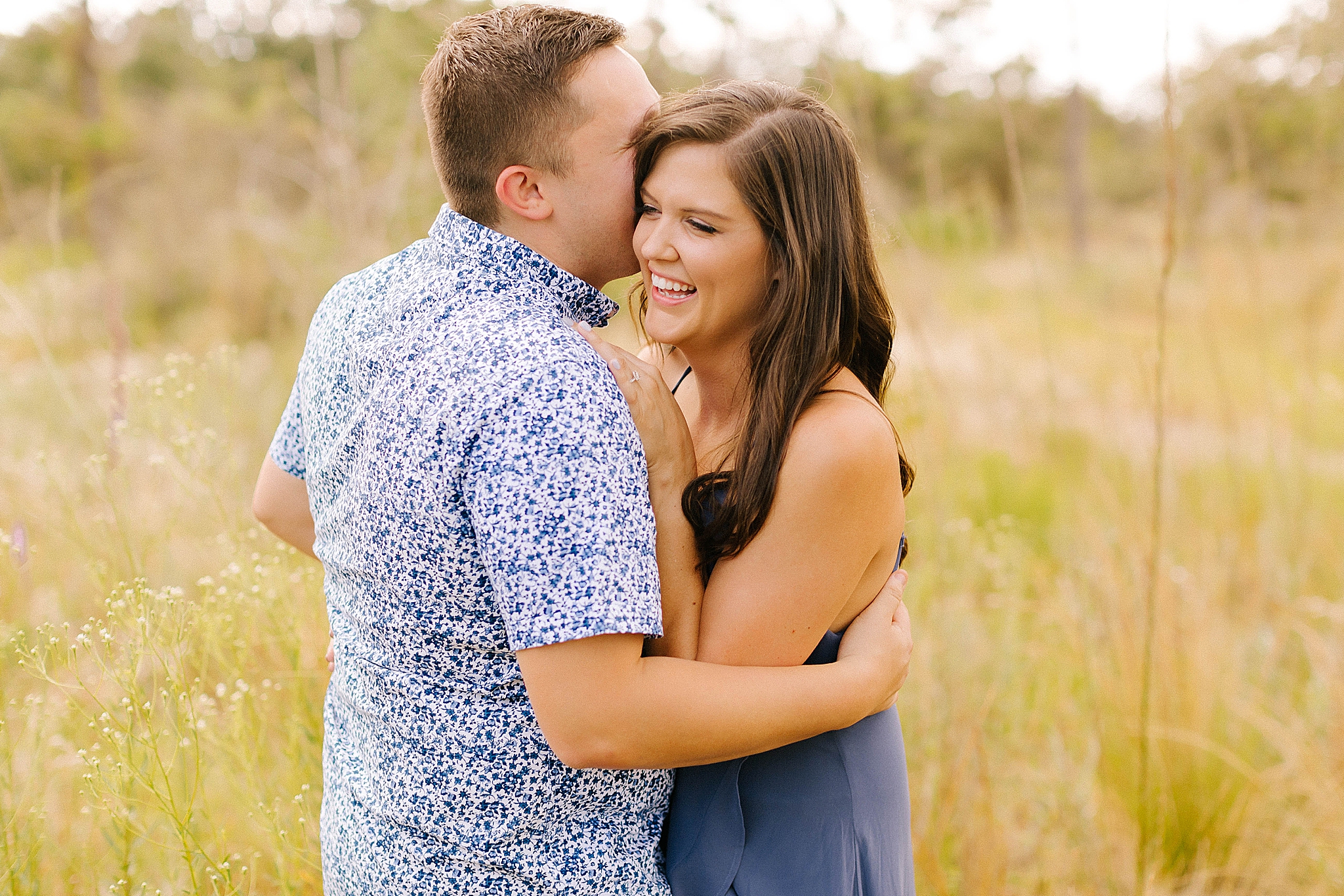 bride and groom in blue outfits laugh during FL engagement session