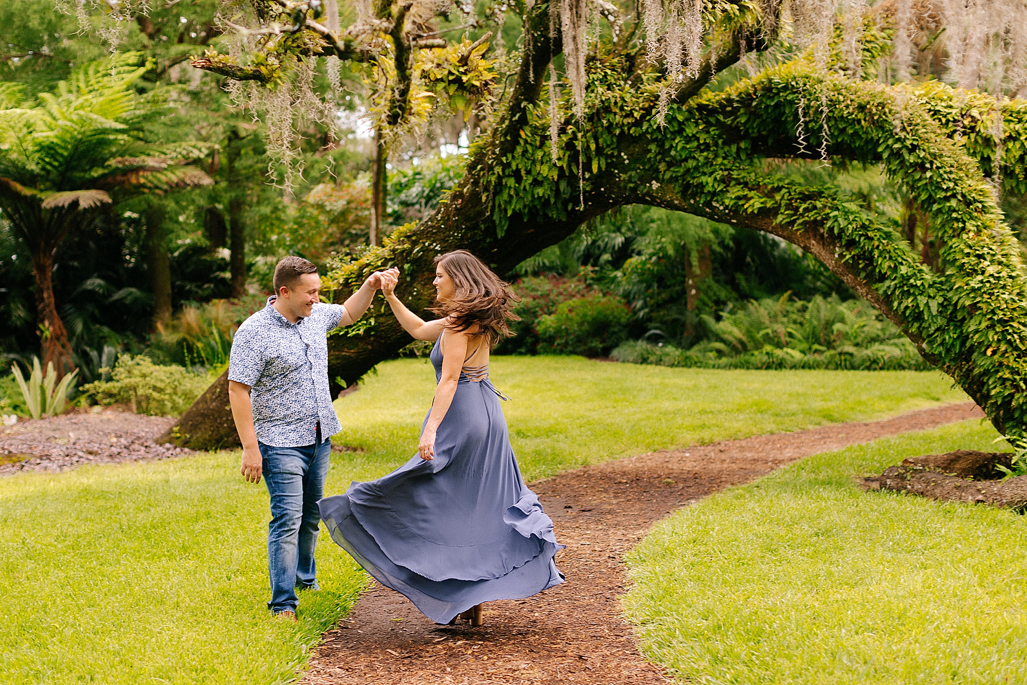 groom twirls bride under Spanish moss at Bok Tower