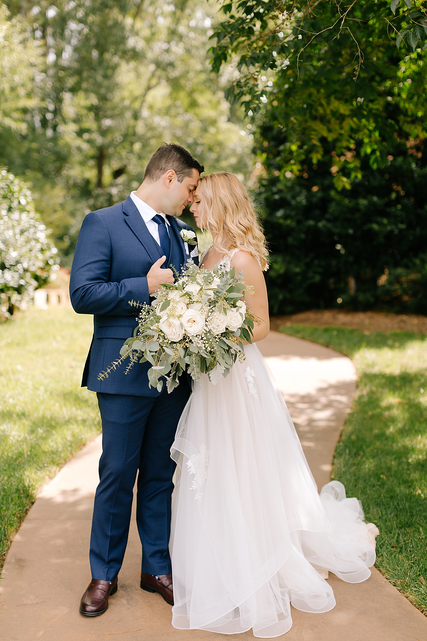 bride and groom stand nose to nose photographed by Chelsea Renay