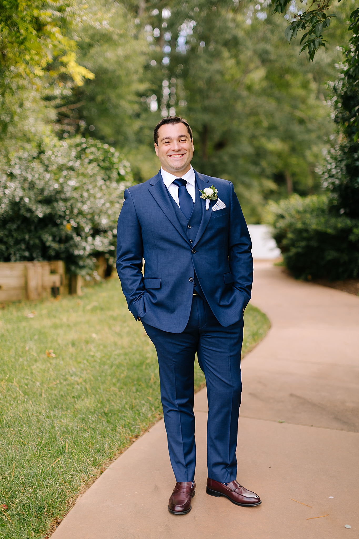 groom in navy suit with ivory boutineere 