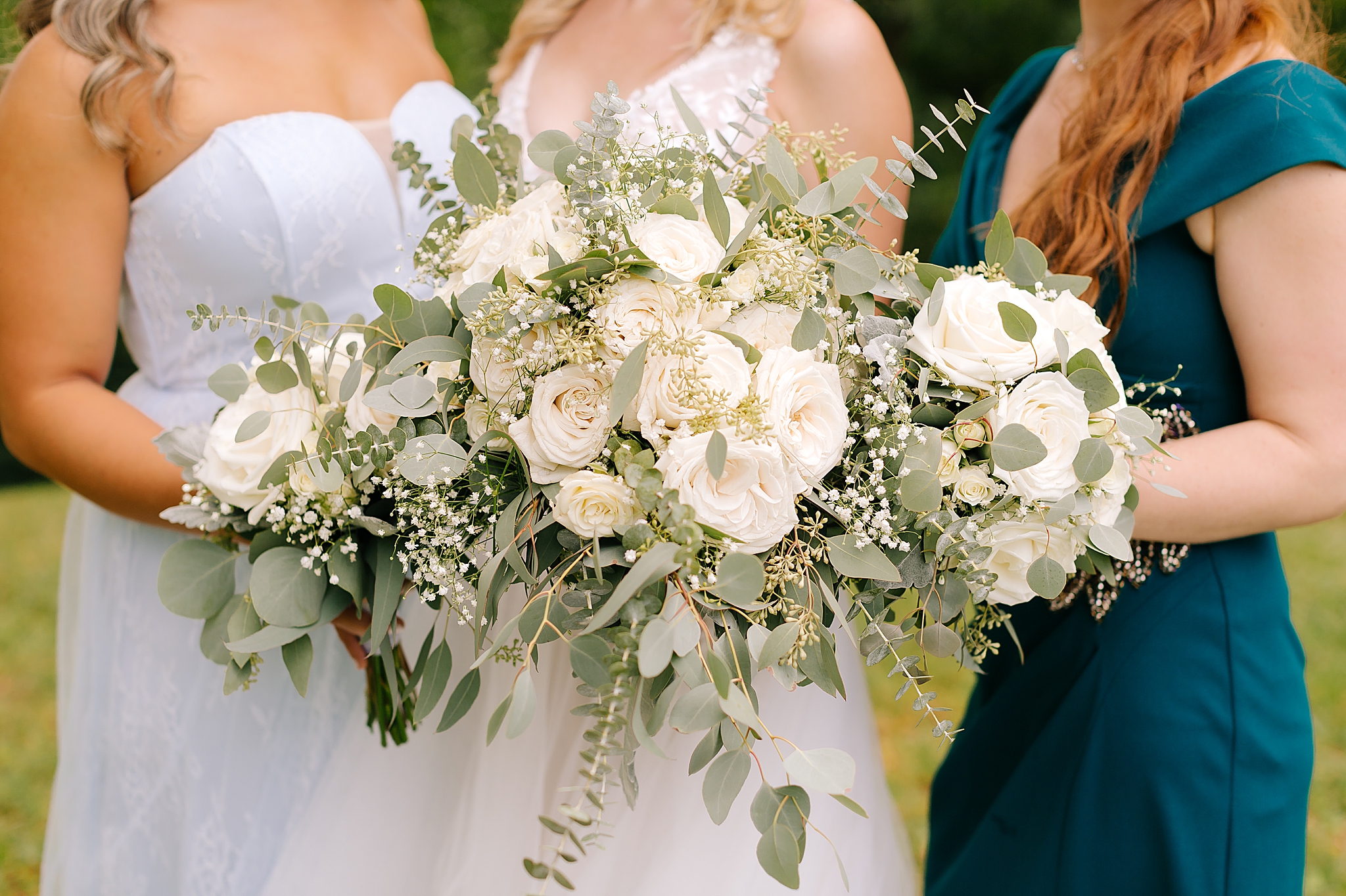 bride and bridesmaids hold bouquet of ivory flowers with eucalyptus 