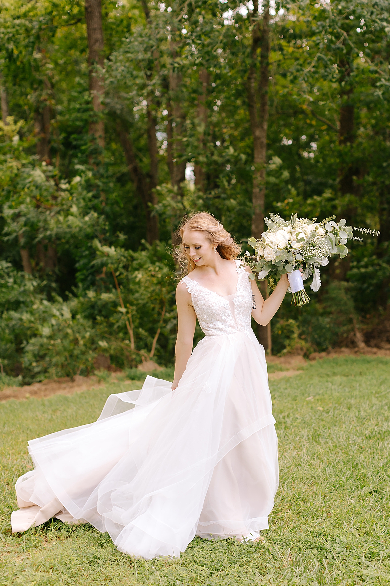 bride twirls wedding gown during NC wedding portraits