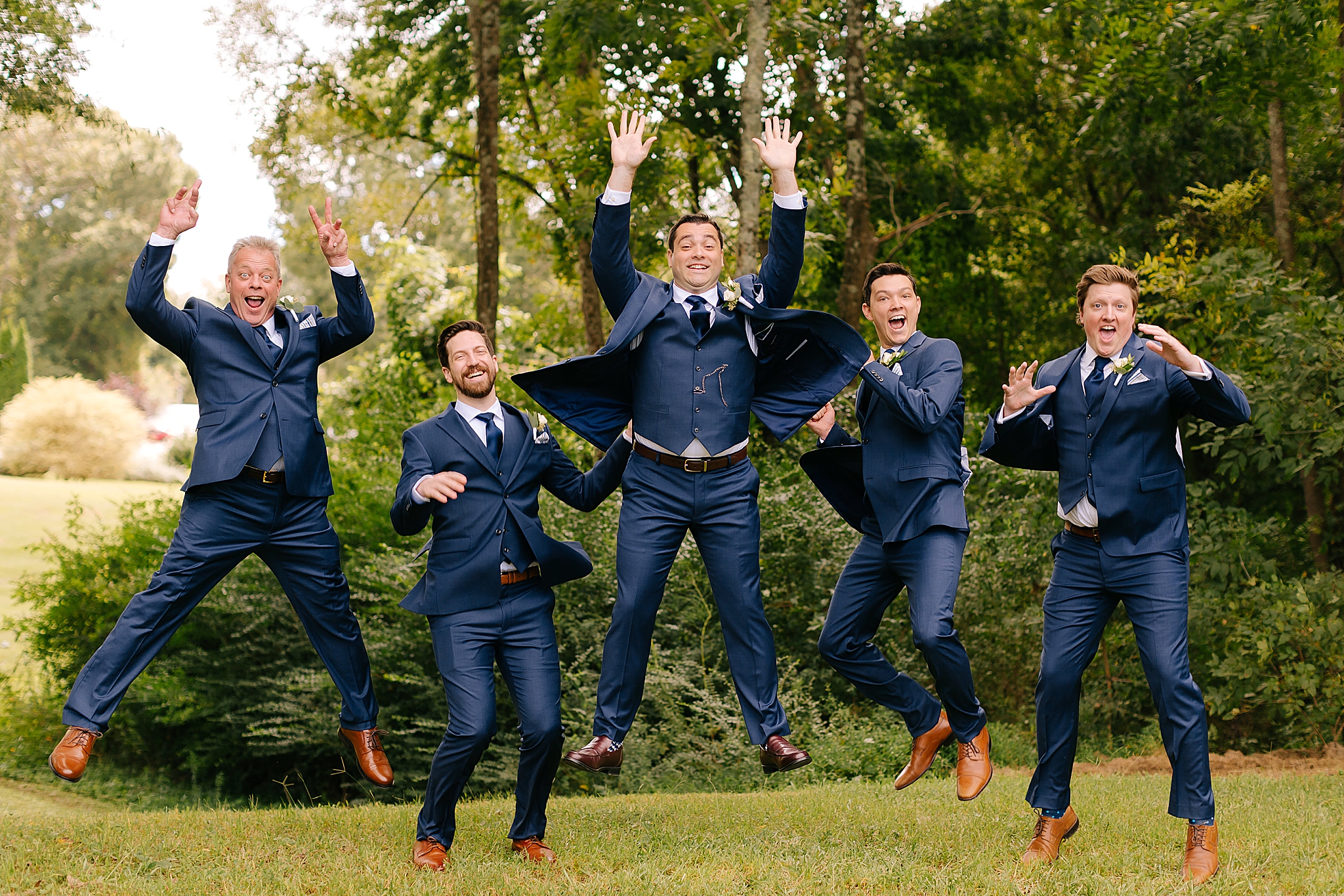 groomsmen jump during wedding party portraits at Camellia Gardens