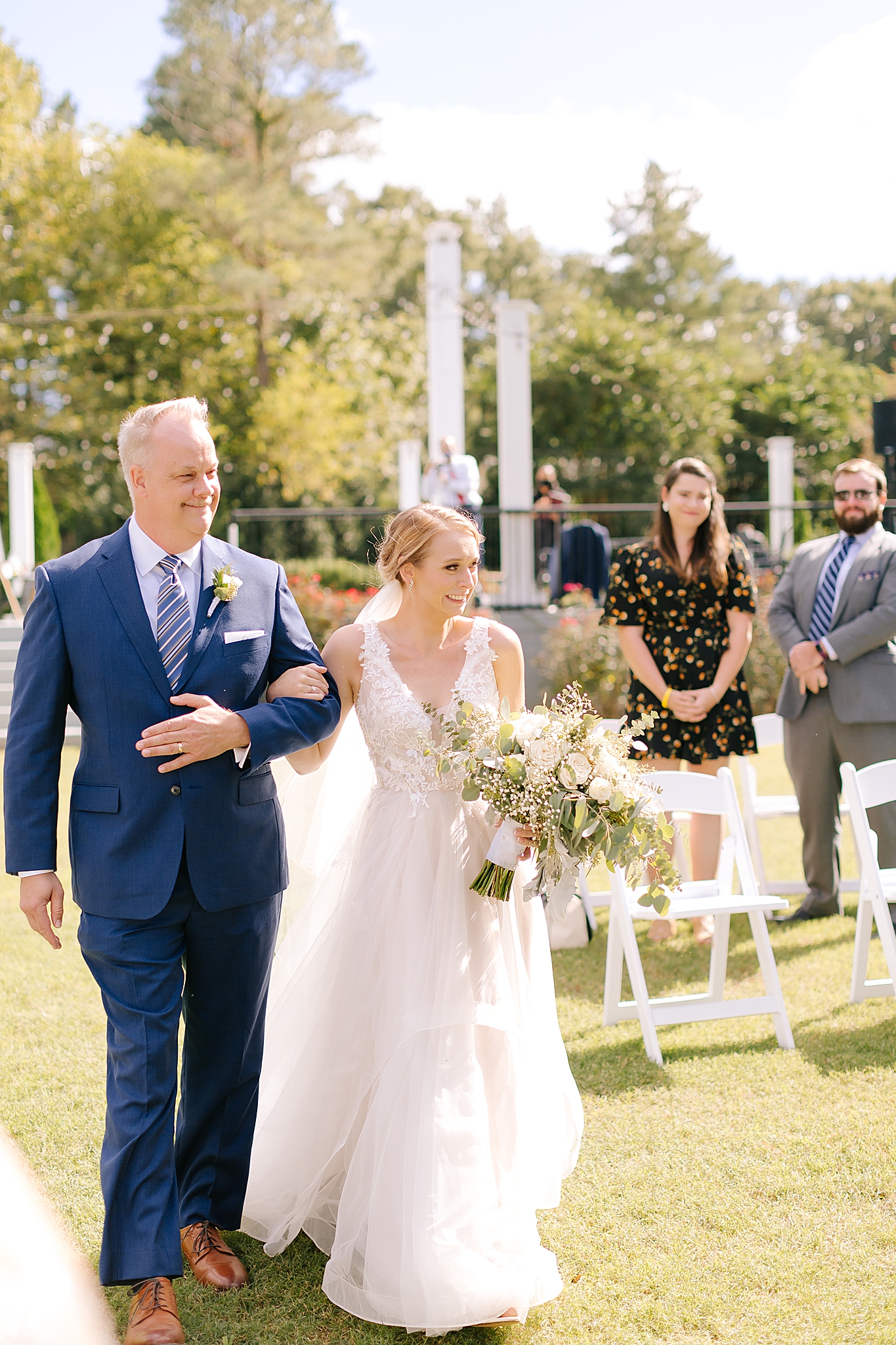 bride walks down aisle with dad at Camellia Gardens