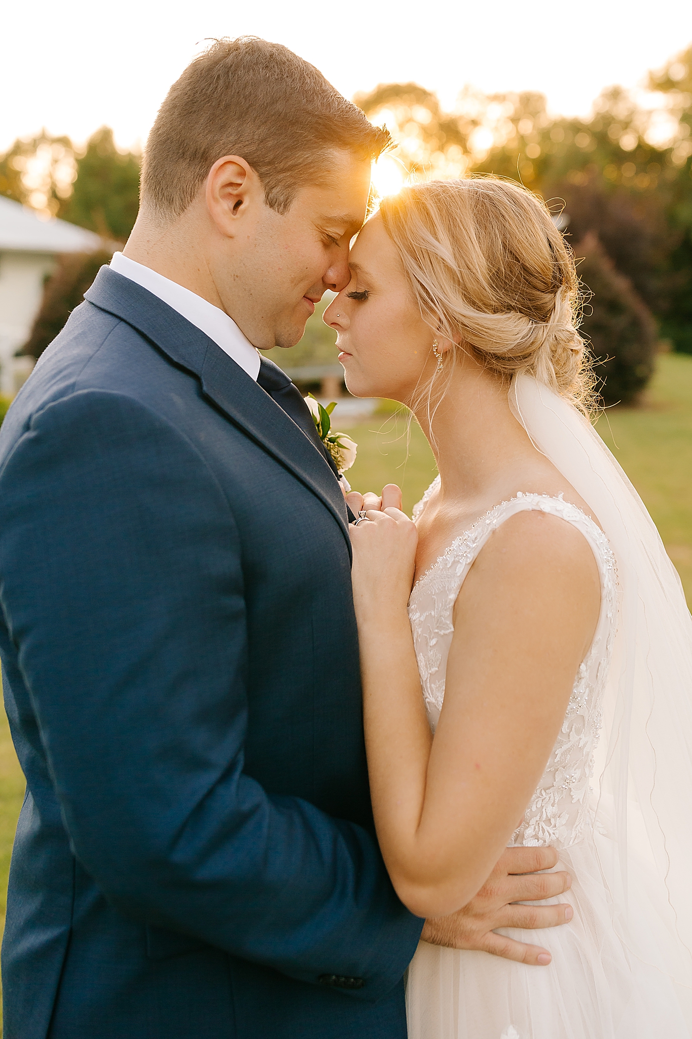 bride and groom stand nose to nose during wedding photos