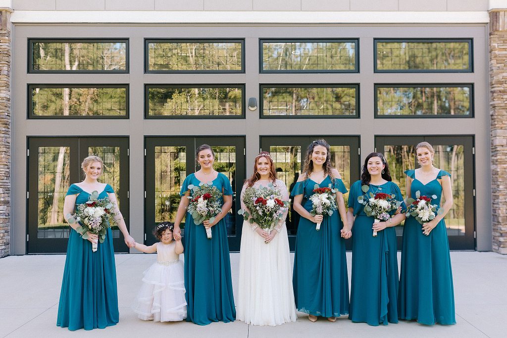 bride poses with bridesmaids outside Southern Charm Events