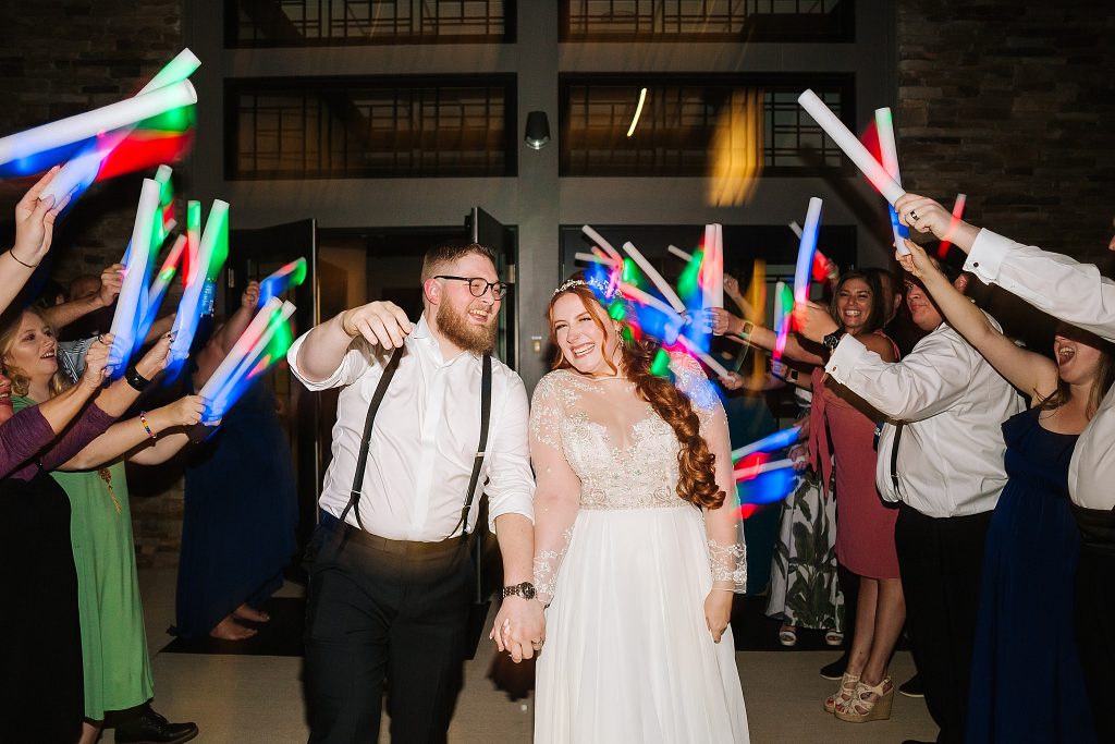 bride and groom walk through glowstick exit