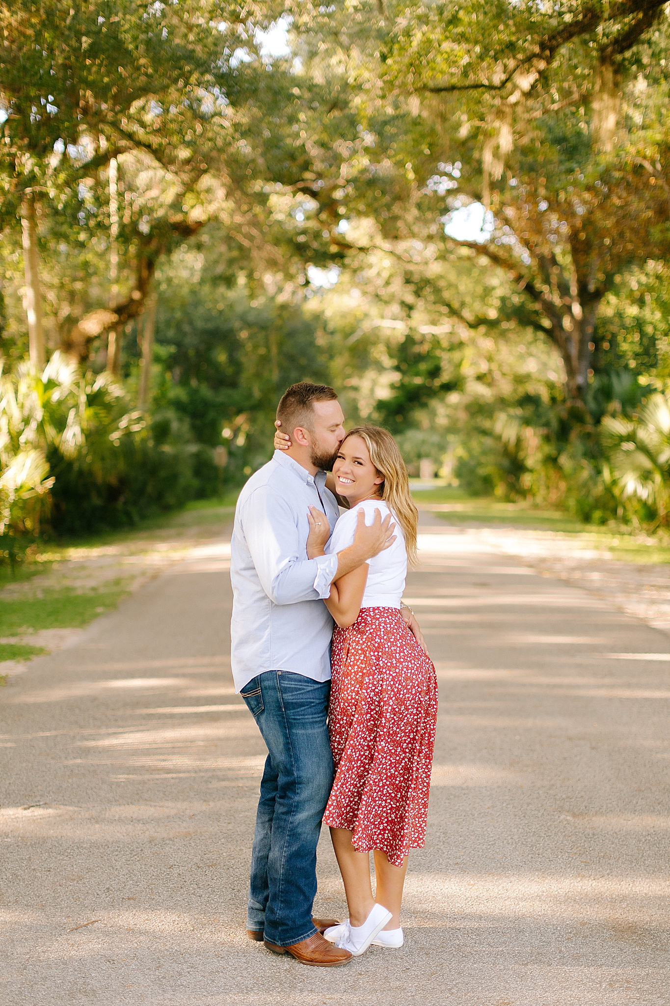 groom hugs bride during Washington Oaks Gardens engagement photos