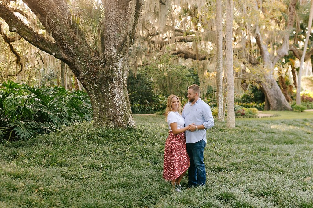 bride and groom stand under trees in Washington Oaks Gardens